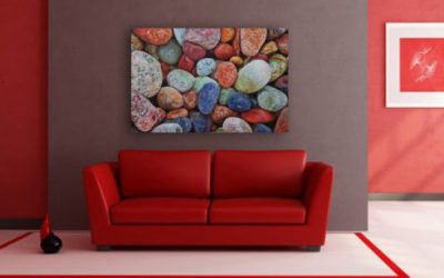 Multi colored rocks on a white washed metal background with gloss.