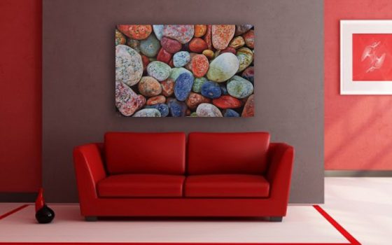 Multi colored rocks on a white washed metal background with gloss.
