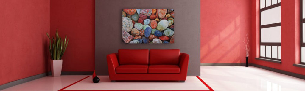 Multi colored rocks on a white washed metal background with gloss.