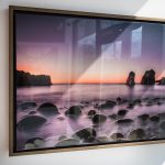 Canvas epoxy print of sunrise over ocean with rocks and fog.