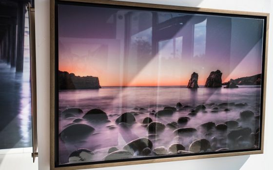Canvas epoxy print of sunrise over ocean with rocks and fog.